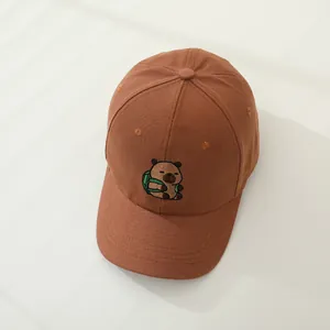 Detalle de la gorra marrón infantil con bordado de carpincho de dibujos con mochila