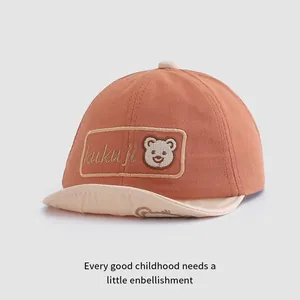 Dettaglio del ricamo a forma di orsetto e delle cuciture su questo cappellino da bimbo