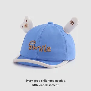 Detailed view of blue baby baseball cap with Smile embroidery and soft cartoon bear ears