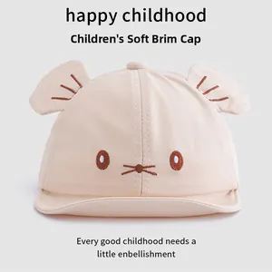 Close-up of beige cotton baby baseball cap with cute 3D ears and cartoon embroidery details
