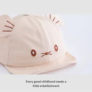 Close-up of cute beige infant baseball cap featuring 3D ears and cartoon cat embroidery