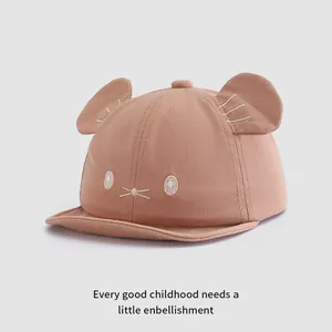 Close-up of baby baseball cap with 3D cat ears and facial embroidery on cotton fabric
