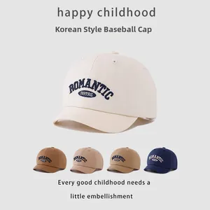 Close-up of five colors of kids' short-brim baseball caps with letter embroidery