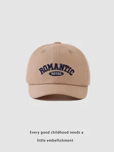 Detail of khaki cotton baseball cap showing blue ROMANTIC embroidery and fabric texture