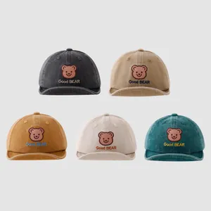 Detail of five assorted colors baby baseball caps featuring cartoon bear embroidery