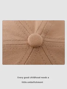 Detailed macro view of the top button and stitched panels on a light brown cotton cap