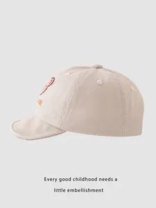 Detailed view of beige cotton baby baseball cap with bear embroidery and soft brim