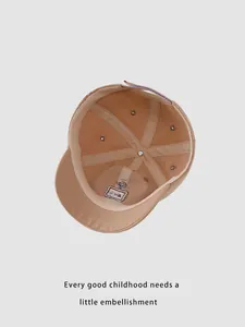 Detail view of khaki kids baseball cap interior with 6-panel stitching and adjustable strap