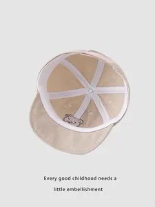 Detail of baby baseball cap interior featuring white cross straps and bear embroidery