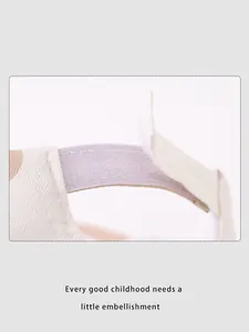 Close-up of adjustable purple hook and loop fastener on beige cotton kids baseball cap