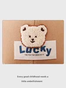 Détail de l'écusson ours en peluche et de l'étiquette Lucky sur casquette en coton kaki