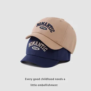 Close-up of embroidered letters on cotton twill baseball caps in khaki and navy blue