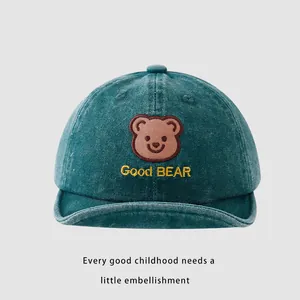 Detail of blue cotton baby baseball cap featuring a brown bear and Good BEAR embroidery