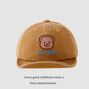 Detailed close-up of brown cotton baby baseball cap with cute bear embroidery and text
