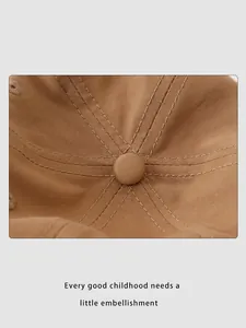 Macro shot of the twill cotton dome and stitching detail on a khaki kids baseball cap