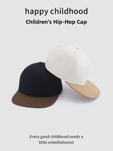 Détail de deux casquettes hip-hop pour enfants aux couleurs contrastées avec bord plat en coton