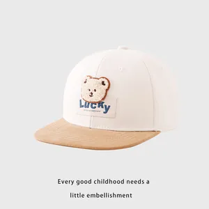 Détail de l'écusson ours en peluche et broderie Lucky sur casquette enfant à bord plat