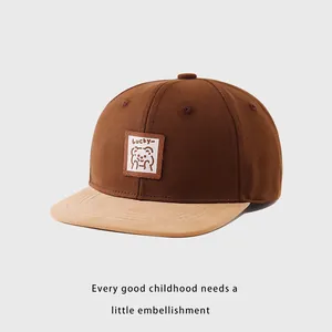 Detalle del parche de oso LUCKY en una gorra de béisbol bicolor para niños