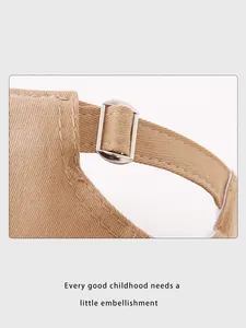 Detailed macro view of the adjustable metal buckle on a twill cotton kids baseball cap