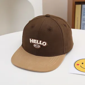 Detalle del bordado HELLO en gorra de béisbol bicolor para niños con visera plana