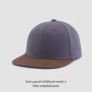 Gros plan d'une casquette de baseball en toile grise avec visière marron et coutures