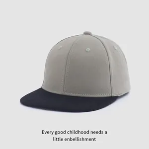 Détail d'une casquette enfant bicolore à visière plate en gris et noir aspect coton