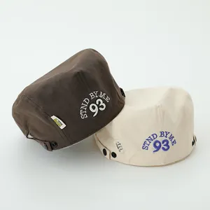 Detail of children's canvas beret with 93 embroidery and side metal button strap
