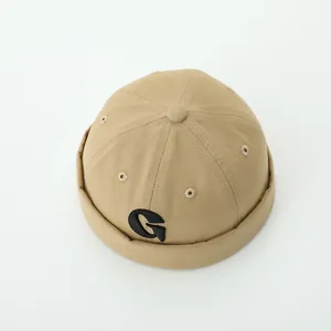 Khaki cotton docker cap for toddlers featuring black embroidered letter G on a white background