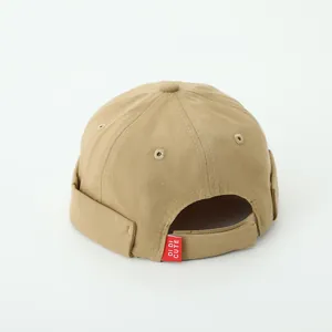 Close-up of khaki docker hat with adjustable velcro strap and red 'DI DI CUTE' label