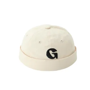 Beige cotton docker cap for kids featuring black G letter embroidery and brimless design