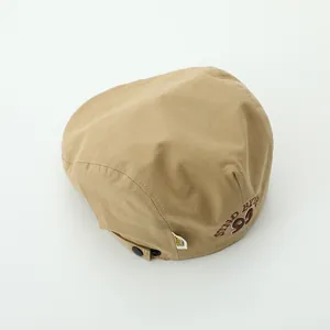Detail of khaki cotton newsboy cap featuring 93 embroidery and adjustable strap