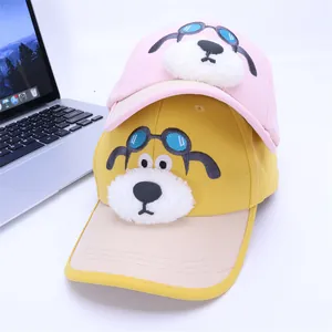Détail de casquettes de baseball chien de dessin animé en rose et jaune avec museaux en peluche