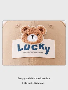 Detailed macro view of the plush brown bear patch and Lucky label on the beige cotton cap