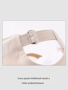 Dettaglio cappellino beige per bambini con fibbia in metallo argento regolabile sul retro