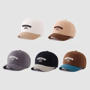 Detail view of five multi-colored cotton baseball caps with embroidered lettering