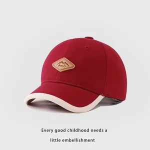 Détail de la casquette rouge pour enfants avec patch en cuir Kukuji et bordure contrastée