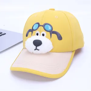 Détail de la broderie de chien et du nez en peluche sur casquette jaune pour enfant