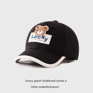 Detailed close-up of a black cotton kids baseball cap with 3D plush bear and Lucky embroidery