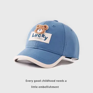 Detail of blue kids baseball cap with plush bear embroidery and Lucky patch