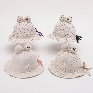 Detail of four polka dot baby sun hats with bunny embroidery and lace brim decoration