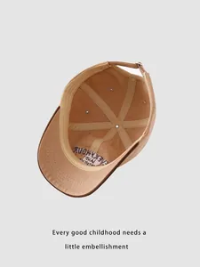 Interior view of khaki kids baseball cap featuring six-panel seams and adjustable strap