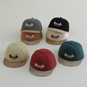 Close-up of cotton baby baseball caps featuring Black EST. 1983 embroidery in multiple colors
