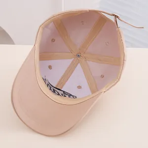 Detailed interior of beige kids baseball cap featuring six-panel seams and metal buckle