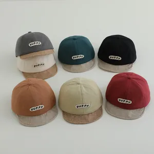 Flat lay of baby baseball caps in seven colors featuring PUPPY patches and textured brims