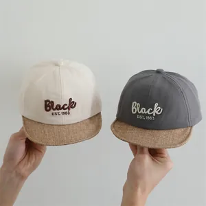 Detailed close-up of baby baseball caps featuring soft linen brims and Black embroidery