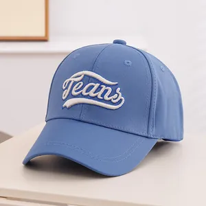 Close-up of blue denim baseball cap featuring 3D white Jeans embroidery and curved brim