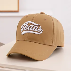 Detailed view of white Jeans 3D embroidery on a khaki cotton baseball cap