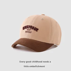 Detail of embroidered letters on cotton kids baseball cap with khaki and brown contrast
