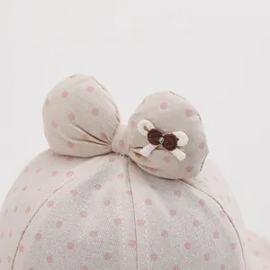 Close-up of baby sun hat with pink polka dots and embroidered bow on decorative ears