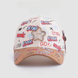 Détail d'une casquette enfant bicolore avec imprimés graffiti et emblème étoile